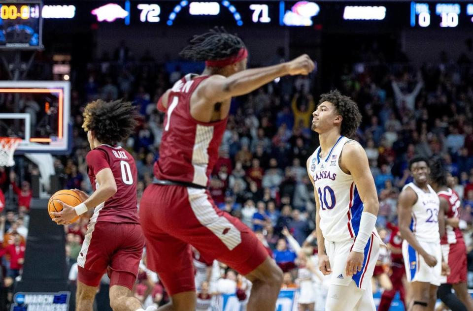 Kansas forward Jalen Wilson (10) walks off the court as Arkansas guard Anthony Black (0) and guard Ricky Council IV (1) celebrate their 72-71 win in a second-round college basketball game in the NCAA Tournament Saturday, March 18, 2023, in Des Moines, Iowa.