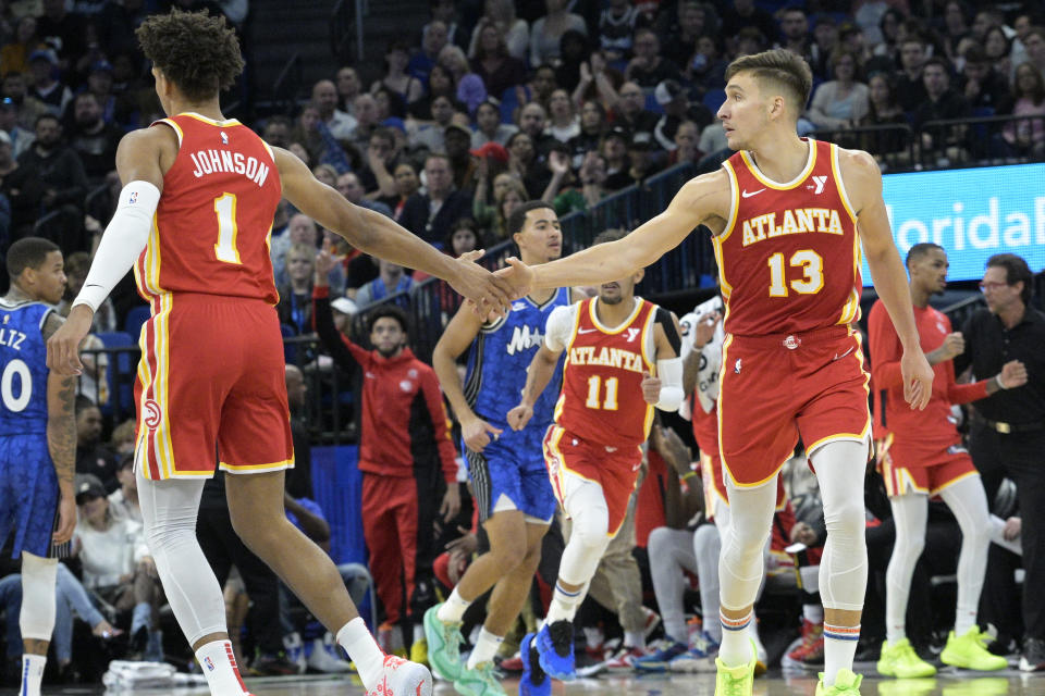 Atlanta Hawks guard Bogdan Bogdanovic (13) is congratulated by forward Jalen Johnson (1) after scoring during the first half of an NBA basketball game against the Orlando Magic, Sunday, Jan. 7, 2024, in Orlando, Fla. (AP Photo/Phelan M. Ebenhack)