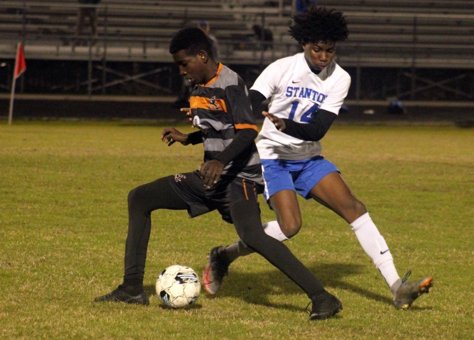 Atlantic Coast midfielder Angelo Philippe (9) spins away from Stanton midfielder Leonard Spears (14) during a Gateway Conference high school boys soccer semifinal.