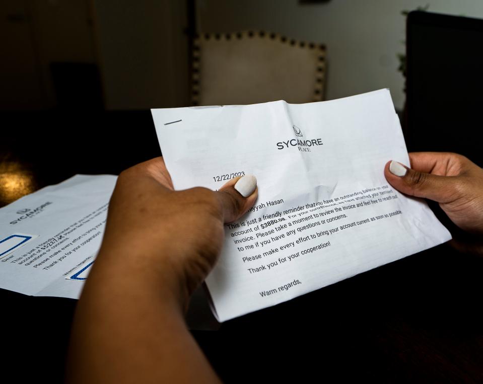 Samiyyah Hasan holds a letter placed under her door detailing the amount of her overdue payments to Sycamore Place.