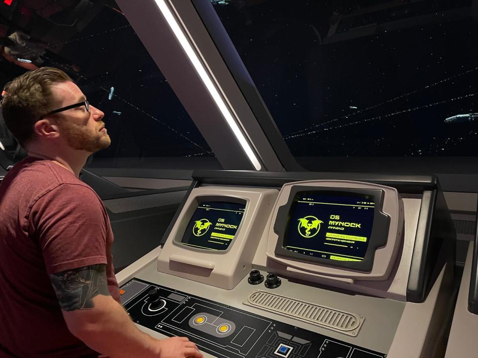 My husband doing bridge training in the Starcruiser, pressing buttons on a futuristic dashboard