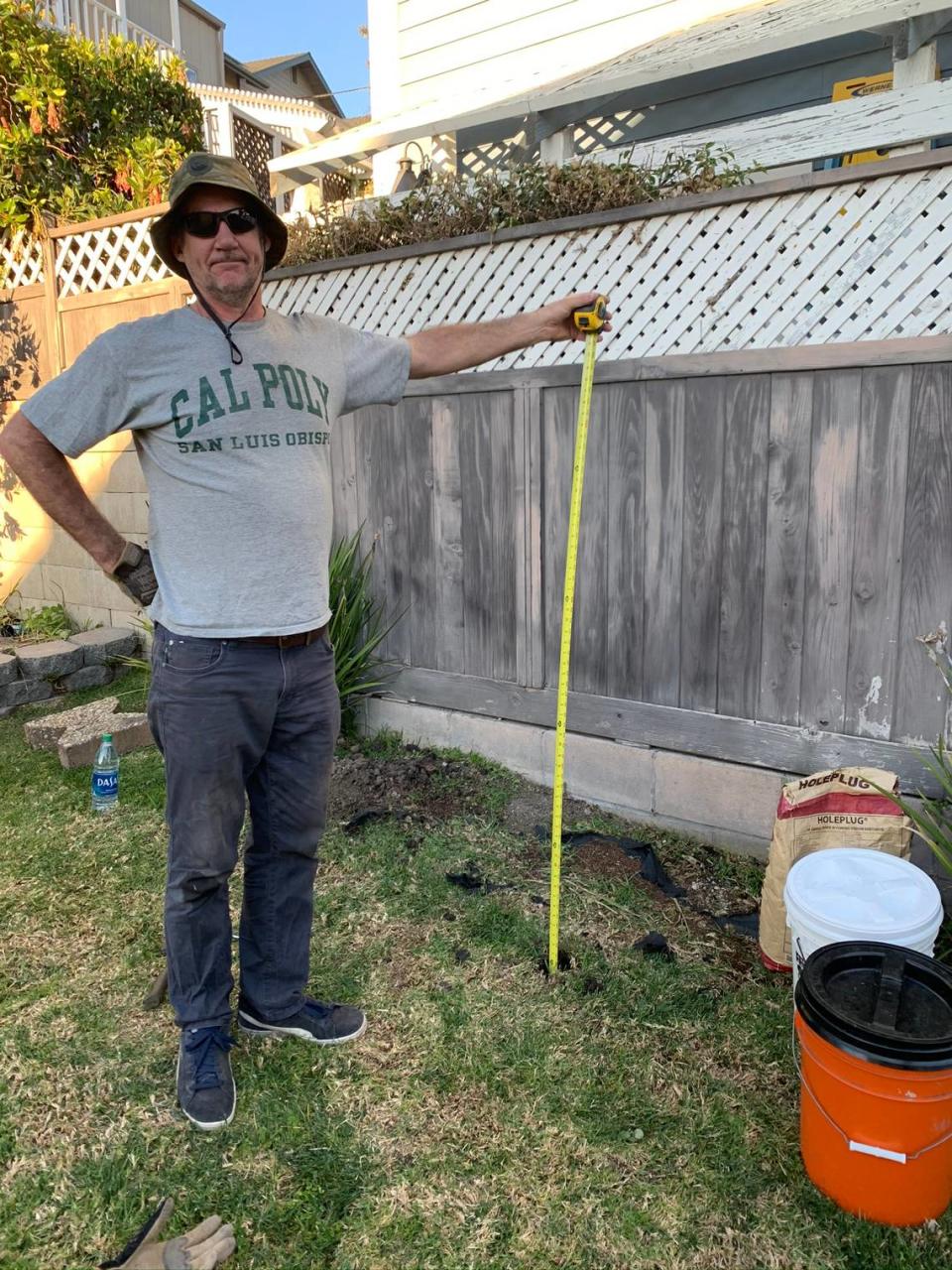 Tim Nelligan stands next to one of the holes they created in Marcia Papich’s yard to measure human decomposition molecules in February 2020, showing the hole he dug was 5 feet down. They were testing for evidence in the search for Kristin Smart’s body.