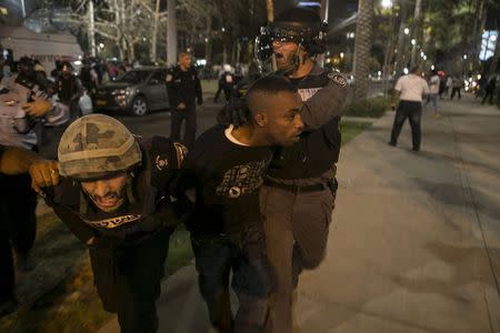 A protester, who is an Israeli Jews of Ethiopian origin, is detained by policemen during a demonstration against what they say is police racism and brutality, after the emergence last week of a video clip that showed policemen shoving and punching a black soldier in a protest at Rabin Square in Tel Aviv May 3, 2015. REUTERS/Baz Ratner