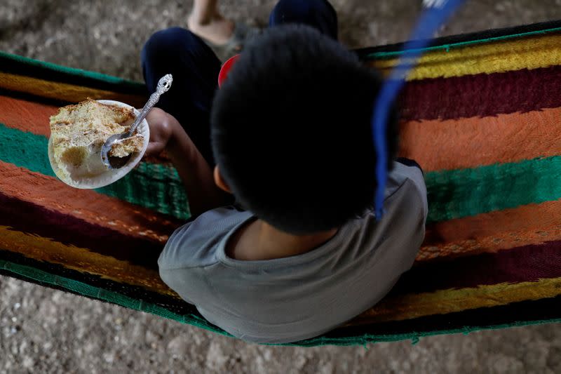 Gustavo, un niño discapacitado de 12 años que fue expulsado por las autoridades estadounidenses a Guatemala bajo una orden de emergencia de salud, sostiene un pedazo de pastel como parte de una fiesta de bienvenida después de reunirse con su padre Juan, en Petén, Guatemala