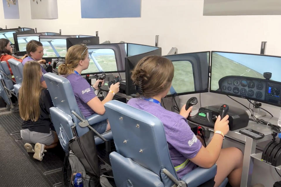 A group of young women from the EAA Girlventure Camp use flight simulators. (Brenda Lea / EAA Girlventure Camp)