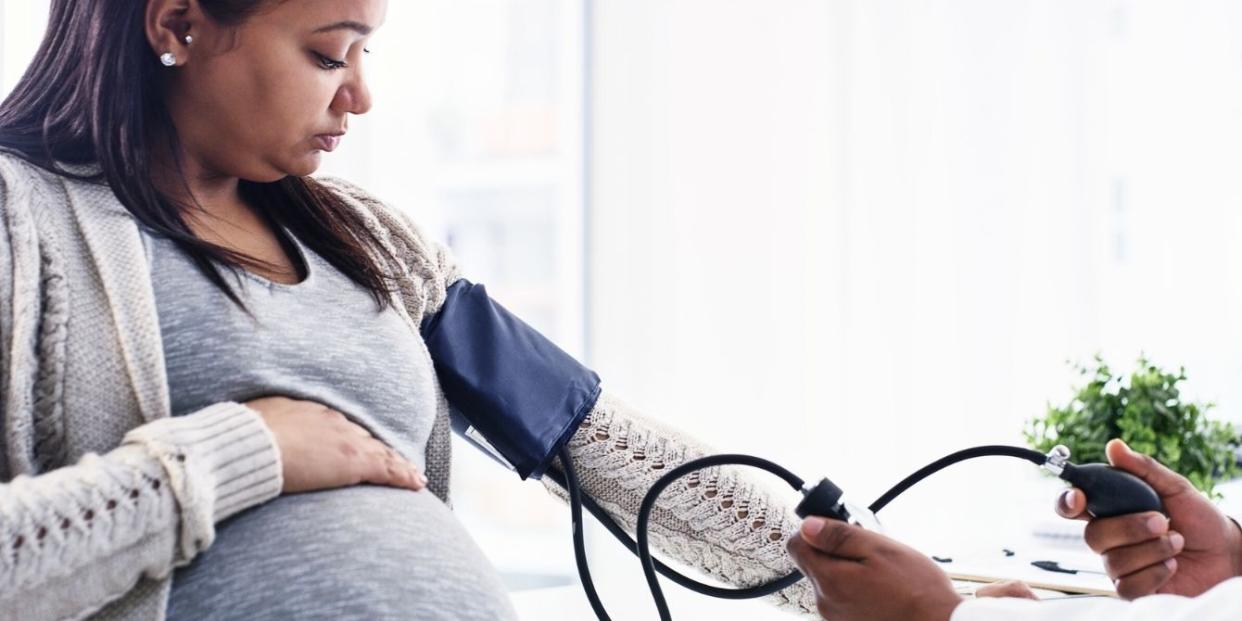 Pregnant woman getting blood pressure tested at the doctor's office