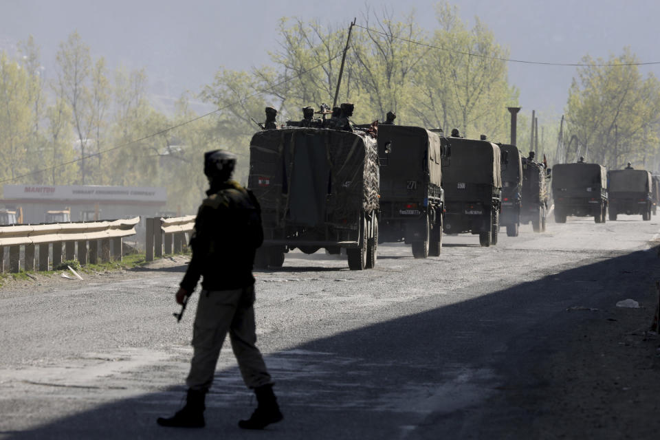 An Indian army soldier stands guard as an army convoy moves on a highway on the outskirts of Srinagar, Indian controlled Kashmir, Sunday, Feb. 7, 2019. Authorities in Indian portion of Kashmir have banned civilian traffic on Srinagar-Jammu national highway for two days in a week for the safe passage of Indian security force convoys. The move comes after the February 14 suicide bombing on a paramilitary convoy which killed more than 40 paramilitary personnel. (AP Photo/Dar Yasin)