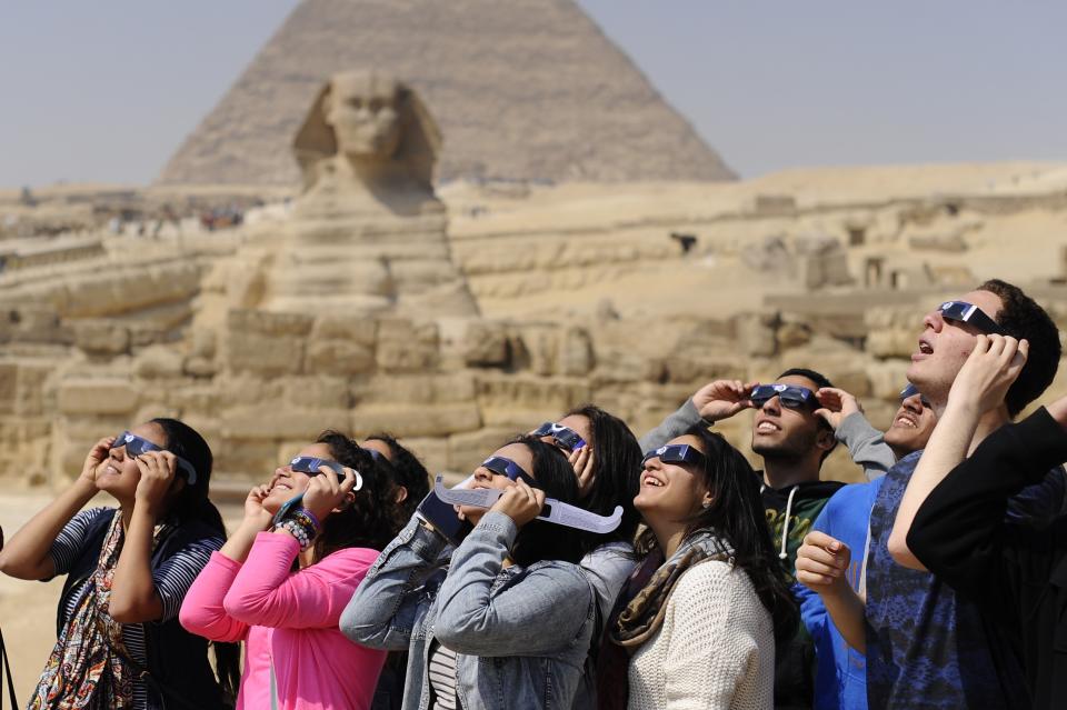 <p>People use protective glasses to catch a glimpse of a solar eclipse in front of Pyramids of Giza and the Sphinx on March 20, 2015 in Giza, Egypt. (Photo: Mohamed Hossam/Anadolu Agency/Getty Images) </p>