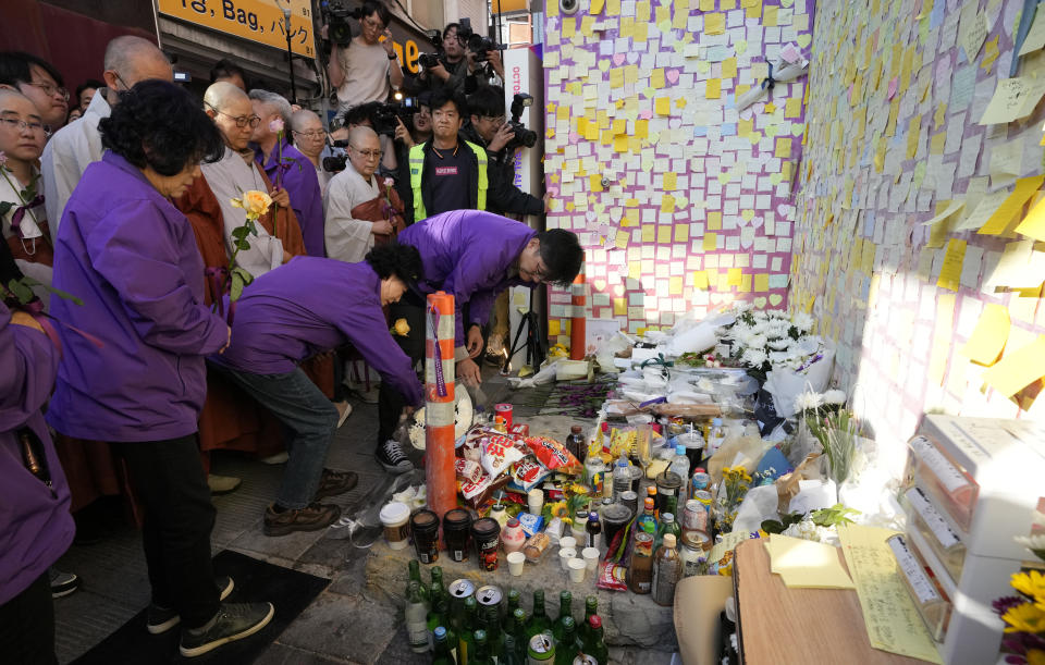 Family members of the victims place flowers during a service to mark the first anniversary of the harrowing crowd surge that killed about 160 people in a Seoul alleyway, at the Itaewon district in Seoul, South Korea, Sunday, Oct. 29, 2023. (AP Photo/Ahn Young-joon)