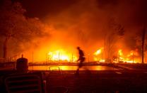 <p>A firefighter walks near a pool as a neighboring home burns in the Napa wine region in Calif. on Oct. 9, 2017, as multiple wind-driven fires continue to whip through the region. (Photo: Josh Edelson/AFP/Getty Images) </p>