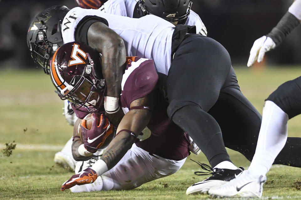 BLACKSBURG, VA - NOVEMBER 09: Running back Deshawn McClease #33 of the Virginia Tech Hokies is tackled by defensive lineman Carlos Basham Jr. #9 of the Wake Forest Demon Deacons in the second half at Lane Stadium on November 9, 2019 in Blacksburg, Virginia. (Photo by Michael Shroyer/Getty Images)