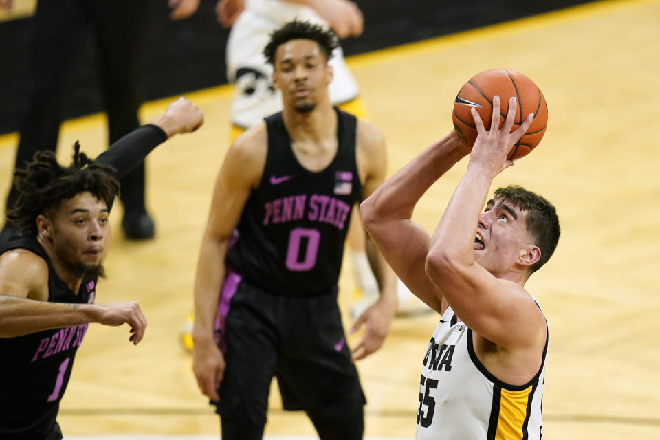 Iowa center Luka Garza, right, drives to the basket as he scores and becomes Iowa's all-time leading scorer during the second half of an NCAA college basketball game against Penn State, Sunday, Feb. 21, 2021, in Iowa City, Iowa. (AP Photo/Charlie Neibergall)