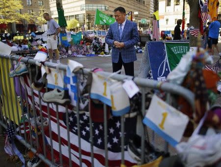 Amir Ismagulov, the father of Azamat Tazhayakov, visits the makeshift memorial for the victims of the Boston Marathon bombings in Boston, Massachusetts May 7, 2013. REUTERS/Brian Snyder/Files