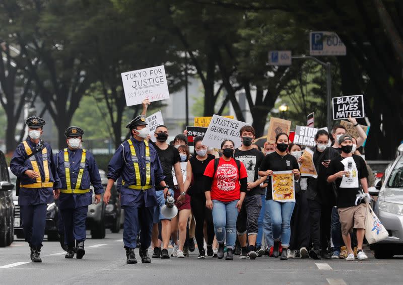 People wearing face masks march during a Black Lives Matter protest following the death in Minneapolis police custody of George Floyd, in Tokyo