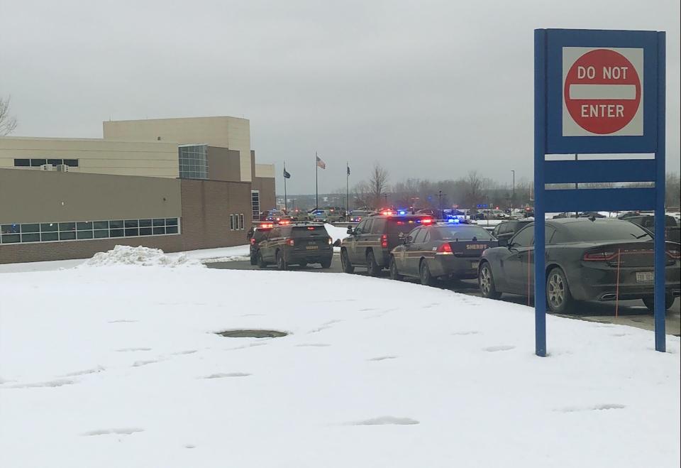 Police cars rush to the scene after a shooting at Oxford High School in Michigan. Police had a teen suspect in custody.