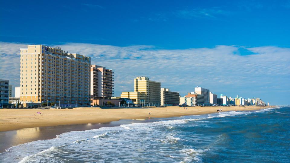 Virginia Beachâ€™s coastal skyline with hotels and condominium towers, and with the Virginia Beach coastline and people in the foreground.