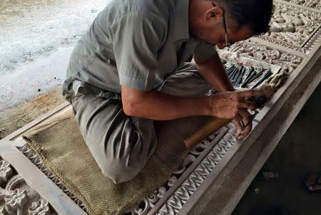 A worker engraves a stone that Hindu nationalist group Vishva Hindu Parishad (VHP) say will be used to build a Ram temple at the disputed religious site in Ayodhya in the northern state of Uttar Pradesh, India, June 16, 2016. REUTERS/Tom Lasseter