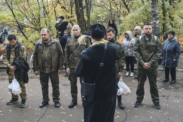 Un sacerdote ortodoxo ruso bendice a hombres reclutados en Moscú el martes 11 de octubre de 2022. En toda la capital, hay notablemente menos hombres en restaurantes, tiendas y reuniones sociales como cenas y fiestas. Muchos han sido llamados a luchar y otros han huido para evitar ser reclutados. (Nanna Heitmann/The New York Times)