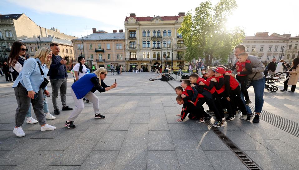 Children and adults take photos in a square in Lviv Oblast in western Ukraine on Friday, May 5, 2023. | Scott G Winterton, Deseret News