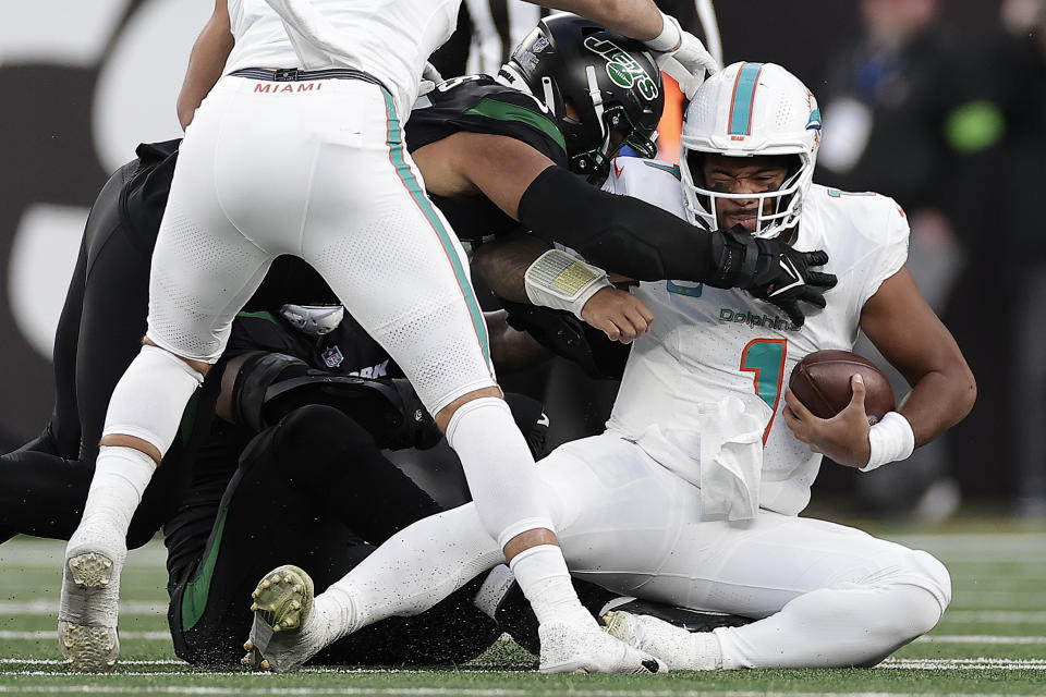 Miami Dolphins quarterback Tua Tagovailoa (1) is sacked by New York Jets defensive end Solomon Thomas (94) during the second quarter of an NFL football game, Friday, Nov. 24, 2023, in East Rutherford, N.J. (AP Photo/Adam Hunger)