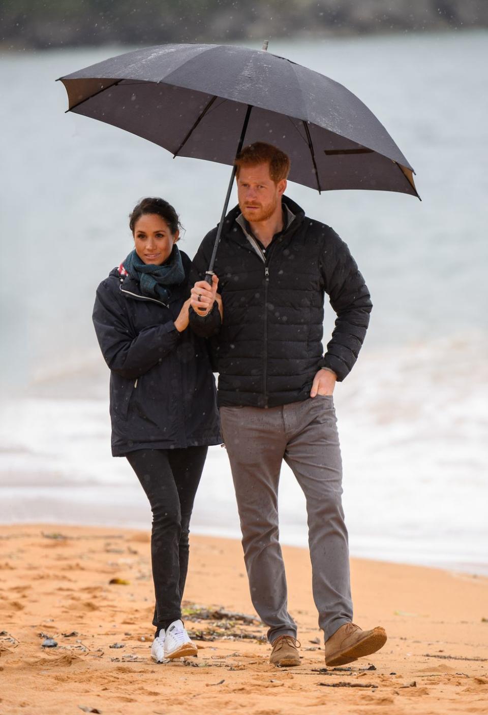 Harry and Meghan share an umbrella as they visit Abel Tasman National Park.