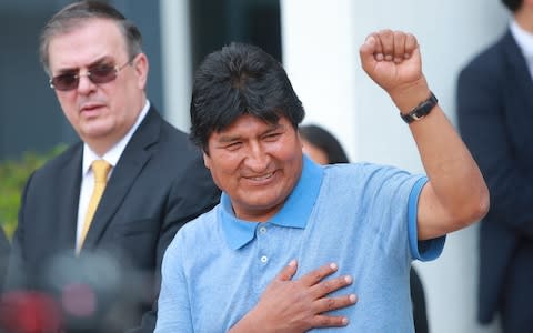 Former Bolivian president Evo Morales greets the press as he arrives to Benito Juarez International Airport after accepting the political Asylum granted by Mexican Government at Benito Juarez International Airport on November 12, 2019 - Credit: Hector Vivas/Getty Images South America