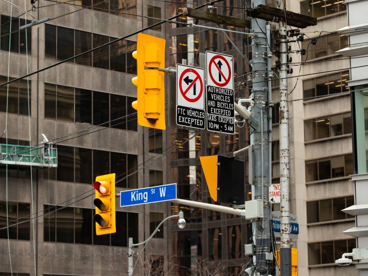 Traffic signs on King Street West at University Avenue are shown here. A redesign of the street seems to have been forgotten, according to a city councillor and a public transit advocate. (Michael Wilson/CBC - image credit)