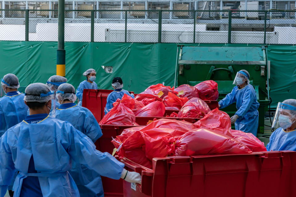 Workers in Hong Kong pile up bags of Covid waste. Source: Getty