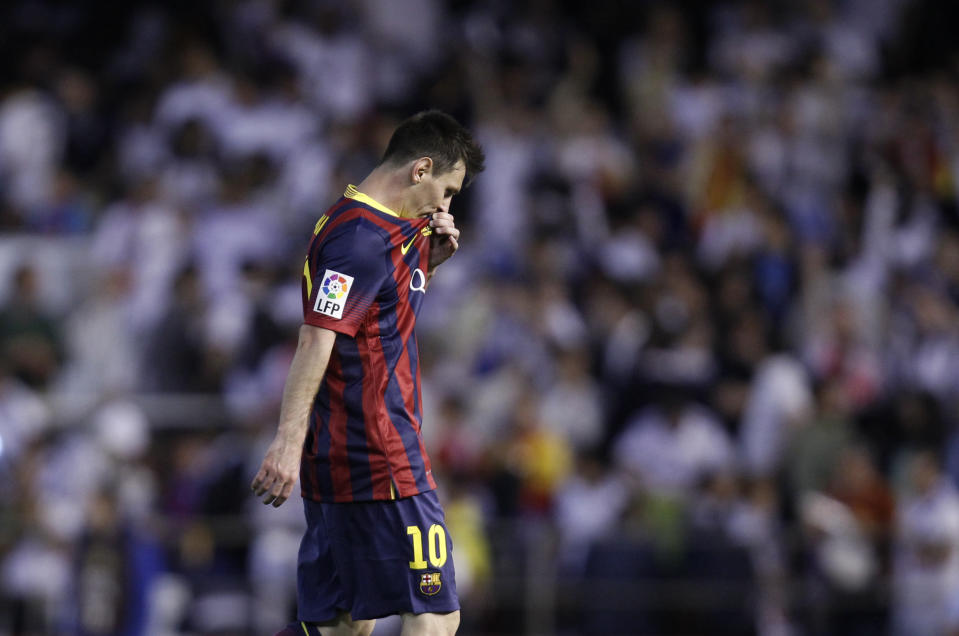 Barcelona's Lionel Messi touches his shirt during the final of the Copa del Rey between FC Barcelona and Real Madrid at the Mestalla stadium in Valencia, Spain, Wednesday, April 16, 2014. (AP Photo/Alberto Saiz)
