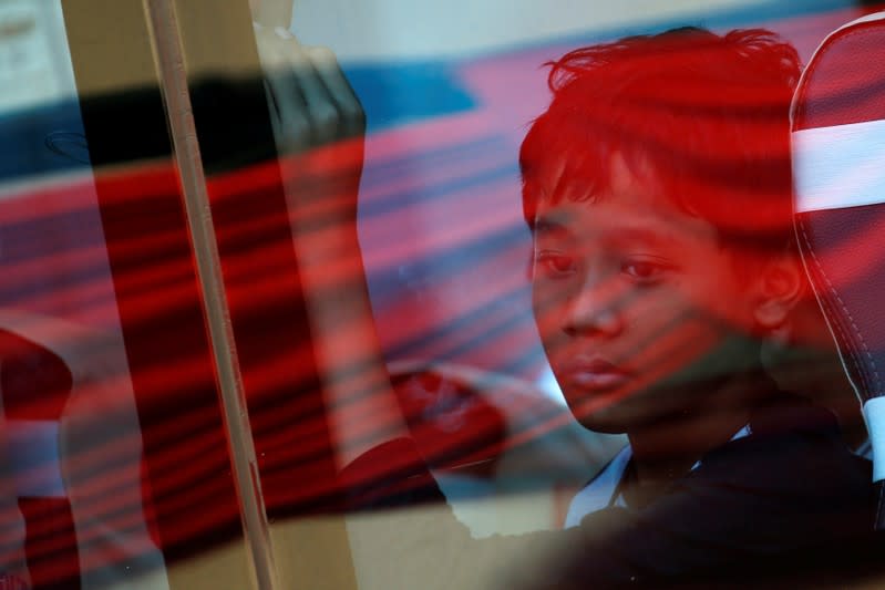 A relative of a passenger who died on Lion Air JT-610 crash at the Java sea, looks through a window as he travels on a bus after attending one-year commemoration of the crash in Jakarta