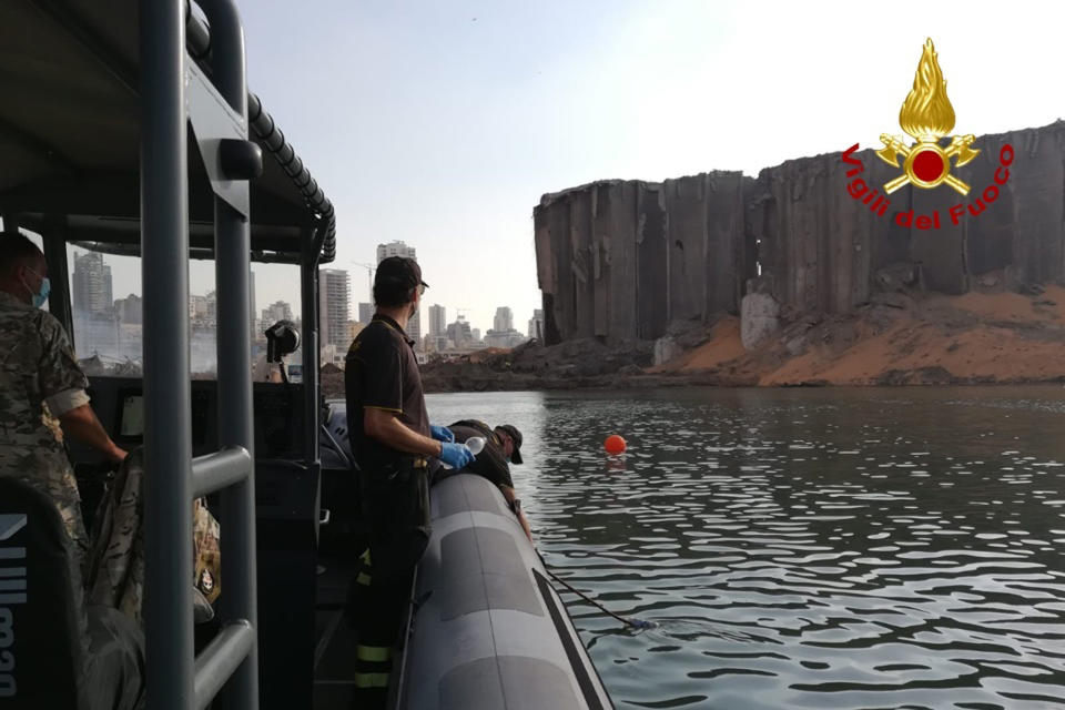 Italian firefighters of the NBCR unit (Nuclear Biological Chemical Radiological) take water samples near the site site of an explosion in the port of Beirut, Lebanon. A massive explosion Tuesday, apparently caused by the ignition of 2,750 tons of ammonium nitrate, a chemical used for explosives and fertilizer, that had been stored at the port, sent a wave of destruction through Lebanon’s capital, killing nearly 150 people and wounding thousands. (Italian Firefighters via AP)