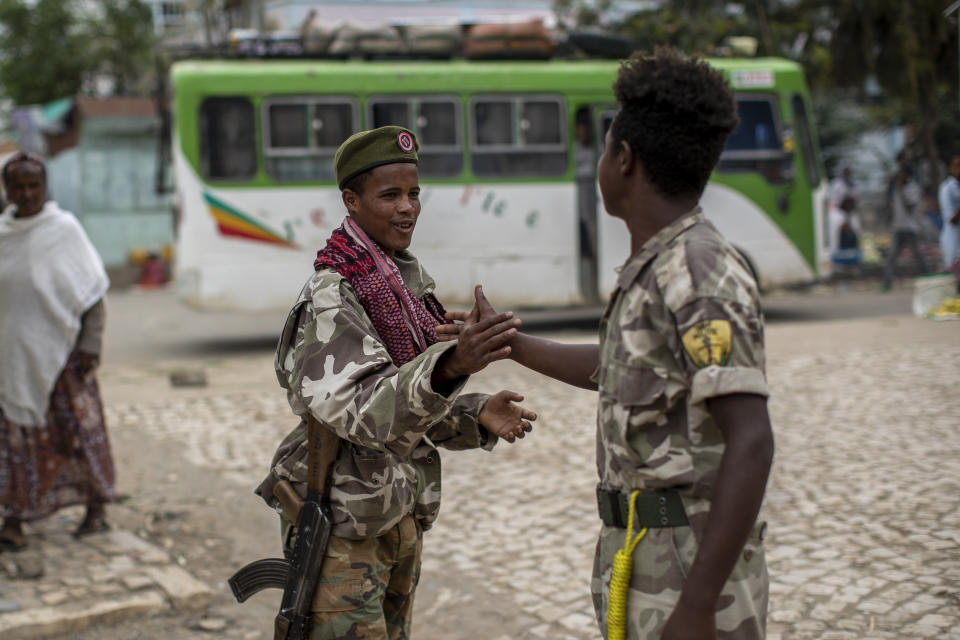 Fighters loyal to the Tigray People's Liberation Front (TPLF) greet each other on the street in the town of Hawzen, then-controlled by the group, in the Tigray region of northern Ethiopia, on Friday, May 7, 2021. The rural town is a microcosm of the challenge facing Prime Minister Abiy Ahmed _ and a warning that the war here is unlikely to end anytime soon. (AP Photo/Ben Curtis)