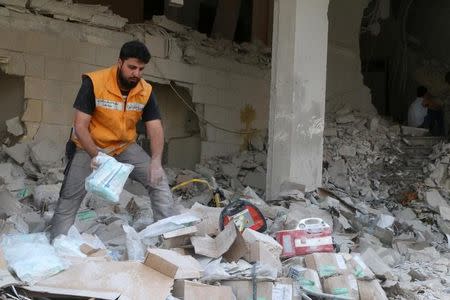 A Red Crescent aid worker inspects scattered medical supplies after an airstrike on a medical depot in the rebel-held Tariq al-Bab neighbourhood of Aleppo, Syria April 30, 2016. REUTERS/Abdalrhman Ismail