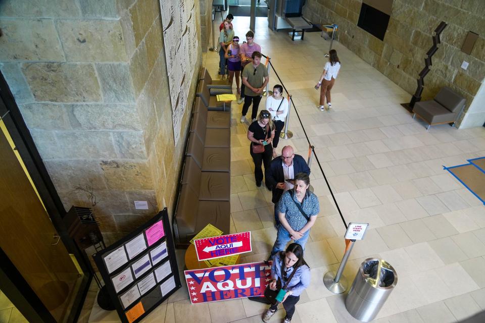 A line of people waits to vote at the Austin City Hall on Super Tuesday. The line stretched around the corner in a waiting area, with voters eager to cast their ballots.