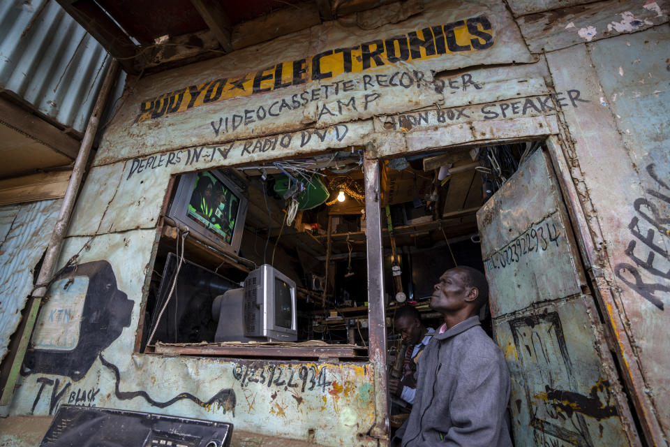 A man watches electoral news on a television in an electronics repair shop in the Kibera area of Nairobi, Kenya Thursday, Aug. 11, 2022. Kenyans are waiting for the results of a close presidential election in which the turnout was lower than usual. (AP Photo/Ben Curtis)