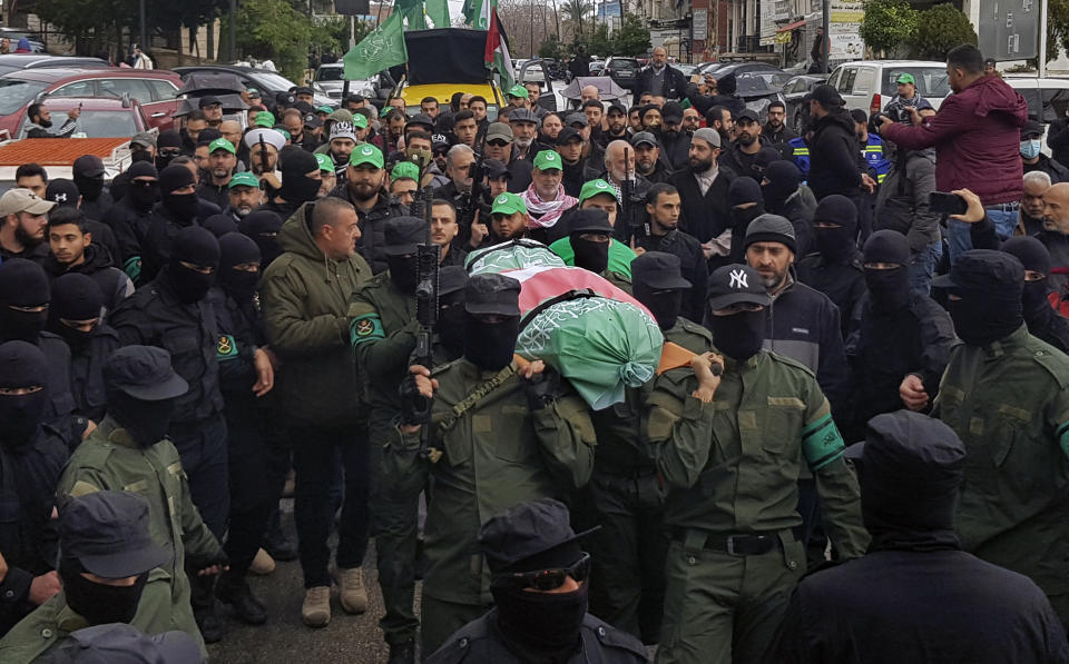 Jamaa Islamiya (Islamic group) gunmen carry the body of their comrade Saeid al-Bashashi, who was killed in an apparent Israeli strike in Beirut on Tuesday with one of the top Hamas commanders Saleh Arouri, during his funeral procession in the southern port city of Sidon, Lebanon, Friday, Jan. 5, 2024. (AP Photo/Mohammed Zaatari)