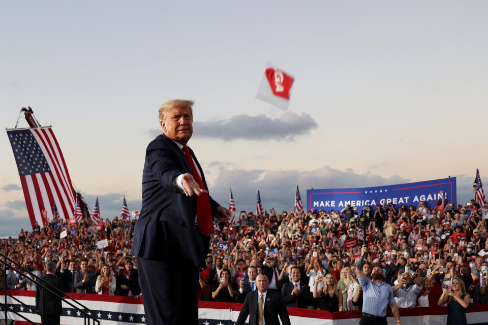 U.S. President Donald Trump throws a face mask from the stage during a campaign rally, his first since being treated for the coronavirus disease (COVID-19), at Orlando Sanford International Airport in Sanford, Florida, U.S., October 12, 2020. REUTERS/Jonathan Ernst     TPX IMAGES OF THE DAY