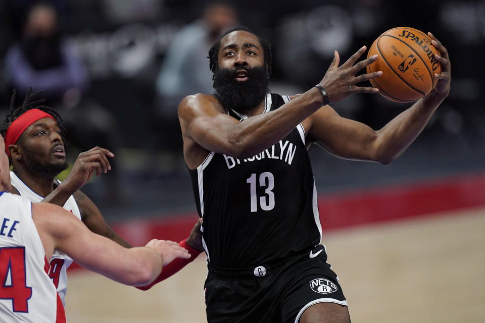 Brooklyn Nets guard James Harden (13) makes a layup as Detroit Pistons forward Jerami Grant (9) defends during the first half of an NBA basketball game, Friday, March 26, 2021, in Detroit. (AP Photo/Carlos Osorio)