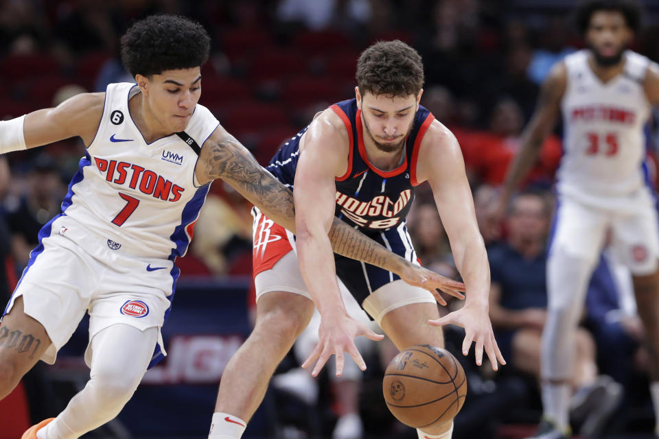 Detroit Pistons guard Killian Hayes (7) reaches for the ball against Houston Rockets center Alperen Sengun during during the first half of an NBA basketball game Friday, March 31, 2023, in Houston. (AP Photo/Michael Wyke)