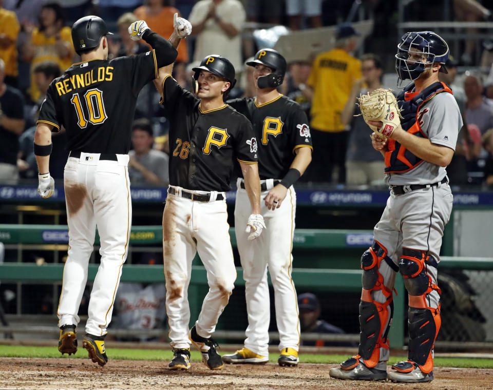 Pittsburgh Pirates' Bryan Reynolds (10) celebrates with Adam Frazier (26) and Kevin Newman after hitting a three-run home run off Detroit Tigers relief pitcher Nick Ramirez during the sixth inning of a baseball game in Pittsburgh, Wednesday, June 19, 2019. (AP Photo/Gene J. Puskar)