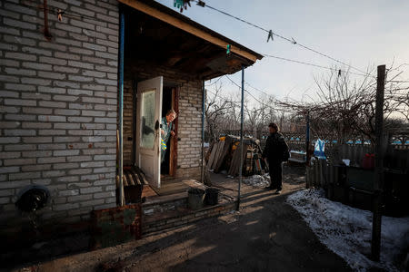 Local resident Raisa Taranenko, 73, speaks with her neighbour pensioner Nikolai Yushkov, 70, near her house, which is around 600 meters from the separatist trenches in Mayorsk, Ukraine, February 22, 2019. Families like that of Yushkov are divided by the conflict. He, his son and daughter live on government-controlled land while another daughter lives under separatist control, where election is not being held. "Everyone says: you need to sit down and you need to negotiate", he said. "Peace. We need peace". The single-storey building he shares with another family has survived shelling that destroyed surrounding buildings but is just 600 metres from the separatist trenches. One outer wall, destroyed by fighting, has been replaced by a stack of firewood. Taranenko, whose family shares the building with Yushkov, also shared his desire for an end to the war. "But it's not clear how the situation will develop. There is no hope for anything", she said. "Everything is getting worse and worse". REUTERS/Gleb Garanich