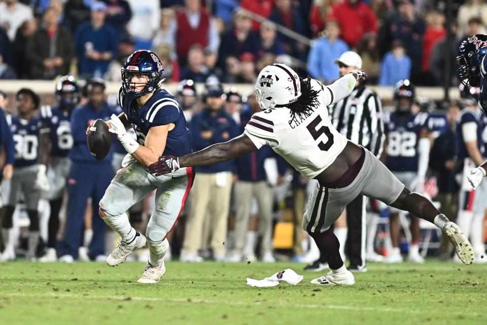 Nov 24, 2022; Oxford, Mississippi, USA; Ole Miss Rebels quarterback Jaxson Dart (2) moves in the pocket while defended by Mississippi State Bulldogs defensive end Randy Charlton (5) during the second quarter at Vaught-Hemingway Stadium. Mandatory Credit: Matt Bush-USA TODAY Sports