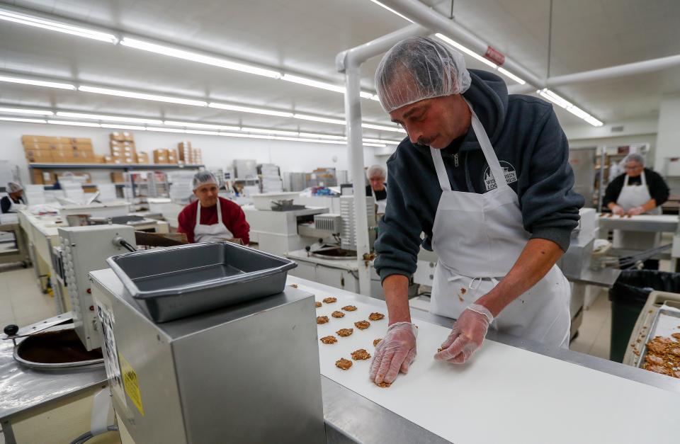 Jeff Diederich prepares chocolate treats for processing on Dec 15 at Seroogy's Chocolates in De Pere.