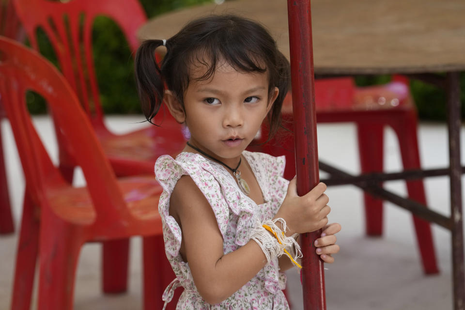 Paweenuch Supolwong, 3, the only child to emerge unscathed from the mass killing attack at the day care center, waits at the Wat Si Uthai temple in Uthai Sawan, north eastern Thailand, Saturday, Oct. 8, 2022. A former police officer burst into a day care center in northeastern Thailand on Thursday, killing dozens of preschoolers and teachers before shooting more people as he fled. (AP Photo/Sakchai Lalit)