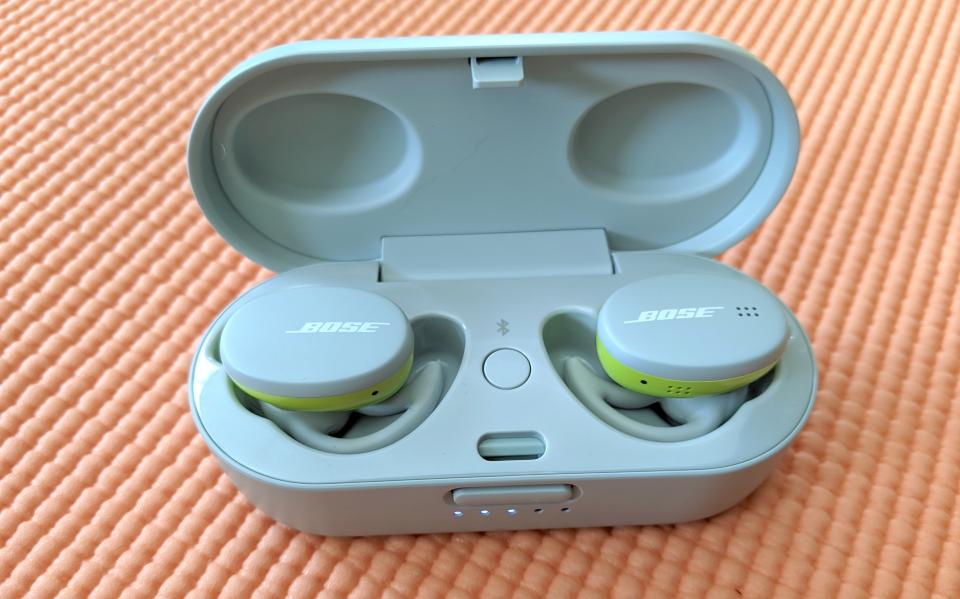 The Bose Sport Earbuds resting on a yoga mat