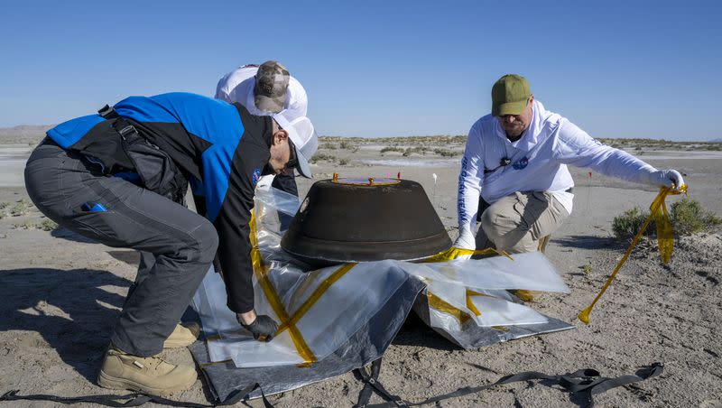 In this photo provided by NASA, from left, Lockheed Martin Mission Operations Assurance Lead Graham Miller, Lockheed Martin Recovery Specialist Michael Kaye, and Lockheed Martin Recovery Specialist Levi Hanish, prepare the sample return capsule from NASA’s Osiris-Rex mission for transport after it landed at the Department of Defense’s Utah Test and Training Range on Sunday, Sept. 24, 2023. The sample was collected from the asteroid Bennu in October 2020. 