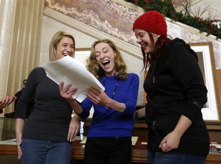 Valerie Scott (C), one of three current and former sex workers who initiated a challenge to Canada's prostitution laws, reacts while reading a copy of the ruling at the Supreme Court of Canada in Ottawa December 20, 2013. REUTERS/Chris Wattie