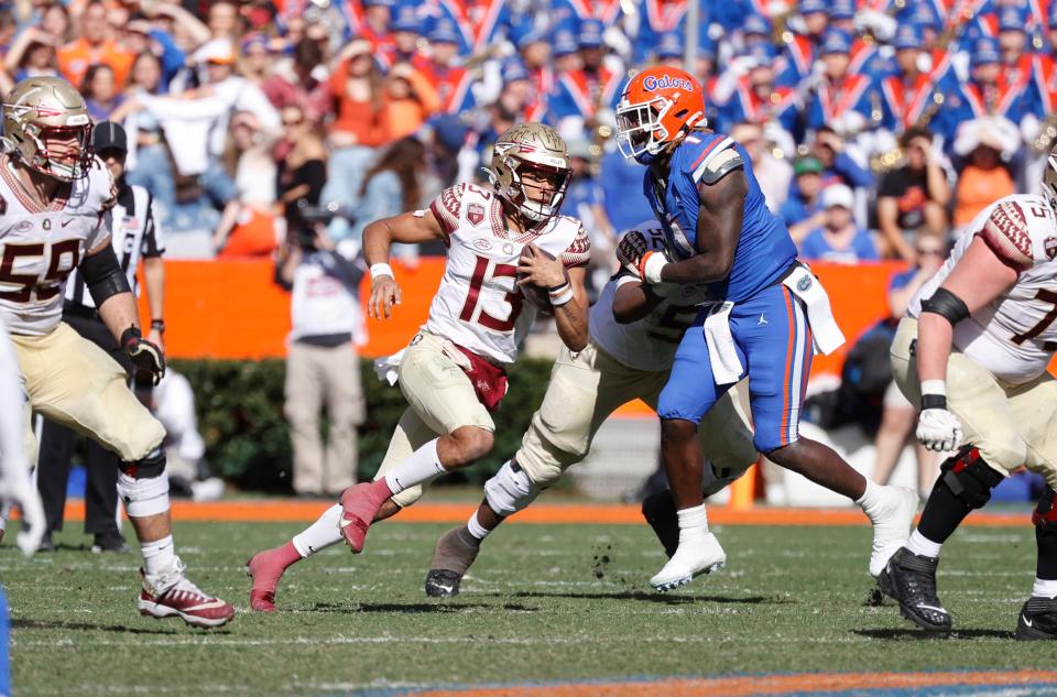 Florida State quarterback Jordan Travis (13) run with the ball against Florida during the second quarter of their 2021 game at Ben Hill Griffin Stadium.