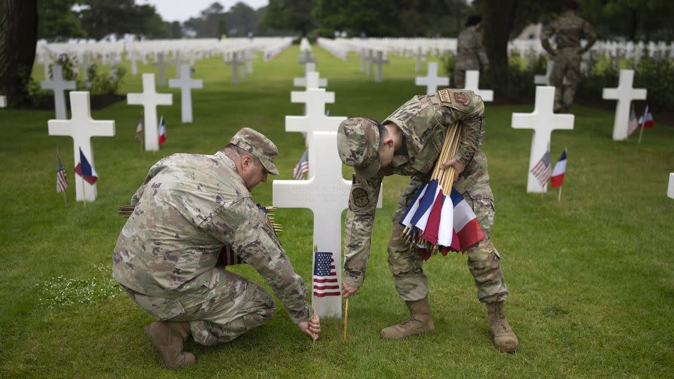 US military personnel place US and French flags next to the graves of fallen soldiers at the Normandy American Cemetery on June 5, 2023 in Colleville-sur-Mer, France. - Christopher Furlong/Getty Images