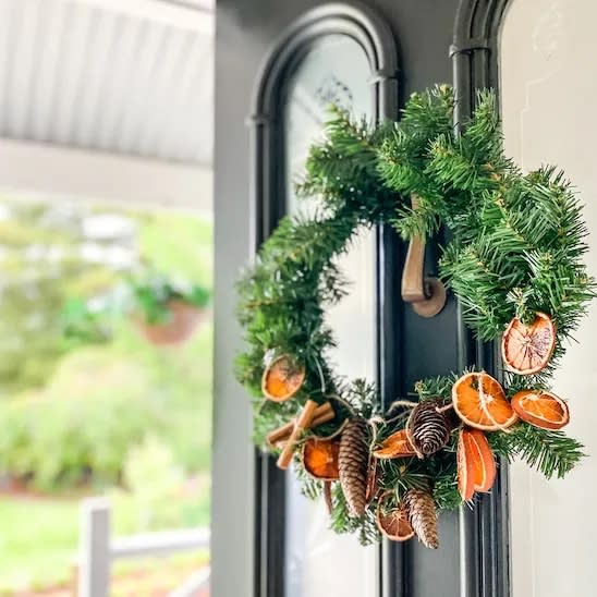 green wreath with dried oranges and pinecones (Our Vintage Farm)